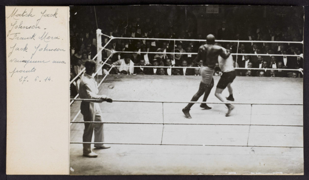 Schwarz-weiß-Foto von zwei Boxern in einem Ring mit einem Schiedsrichter und Zuschauern im Hintergrund, betitelt mit "Jack Johnson vs Frank Morgan".