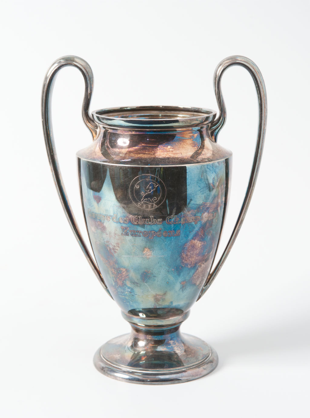 Der UEFA-Champions-League-Pokal, ein stählerner Becher mit zwei Griffen und einem blauen und silbernen Farbschema, der mit «UEFA Champions League» beschriftet ist.