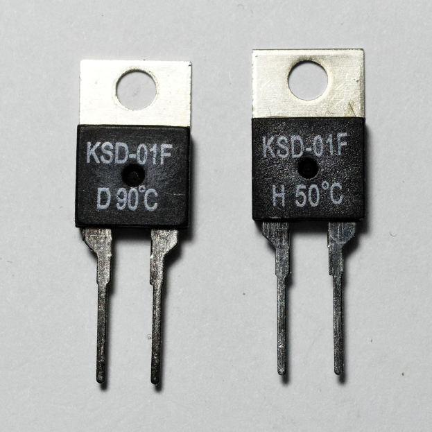 Zwei Transistor-Chips mit der Bezeichnung "KSD-01F" und "D90C" auf einer weißen Oberfläche.