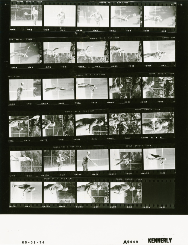 Schwarzes und weißes Foto eines konzentrierten Mannes in einem weißen Hemd und Shorts, der Tennis spielt und einen Schläger in seiner rechten Hand hält, mit einem Filmstreifen im Hintergrund.