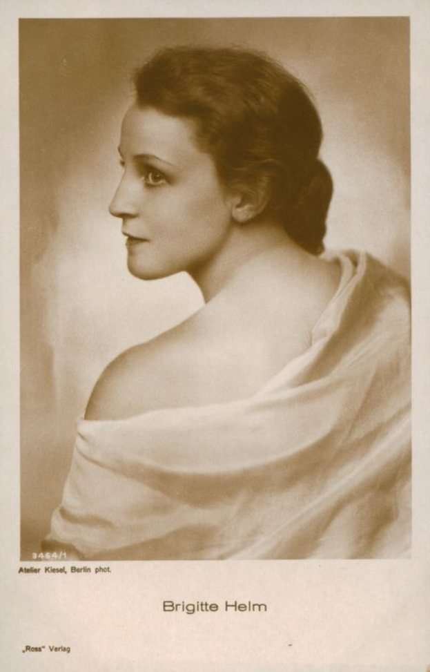 Schwarz-weiß-Porträt von Brigitte Helm, einer deutschen Schauspielerin, in einem weißen Kleid mit Text unten.