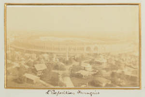 Altes Schwarz-Weiß-Foto eines Stadions inmitten einer Stadt, umgeben von Gebäuden, Bäumen und Strommasten, mit Text unten.