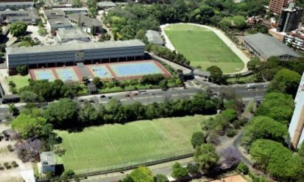 Luftaufnahme eines Fußballfelds in einer städtischen Umgebung, umgeben von Bäumen, Gebäuden und Fahrzeugen, das sich auf dem Campus der University of Sydney als Teil eines neuen Sportkomplexes befindet.