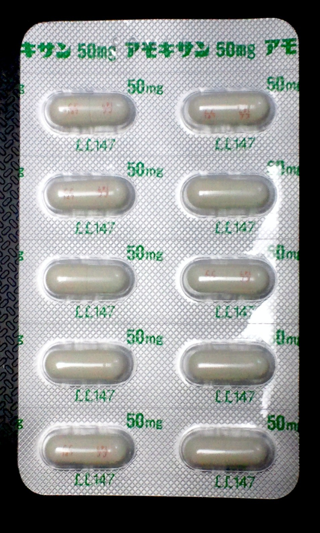 Blisterpackung weißer Pillen mit Text auf schwarzem Hintergrund.