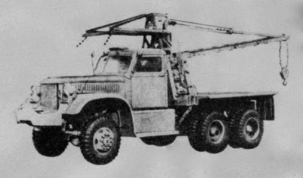 Ein Schwarz-Weiß-Foto eines großen, vierrädrigen Lkw mit einem Kran auf der Rückseite, der als erstes Schwerlastfahrzeug gilt, mit einem flachen Anhänger.