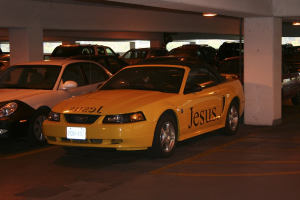 Ein überfüllter Parkplatz mit zahlreichen Autos vor einem Gebäude.