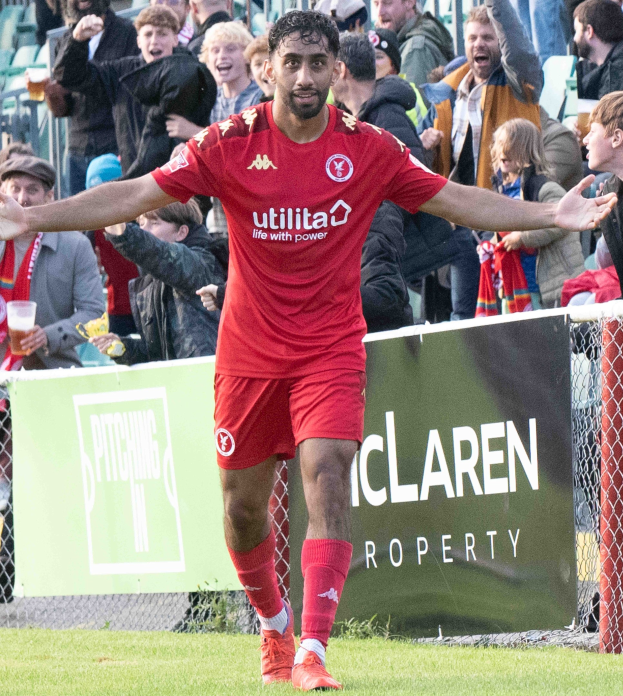 Ein Fussballspieler In Roter Uniform Läuft Auf Einem Feld Mit Ausgestreckten Armen, Umgeben Von Zuschauern, Mit Einem "Middlesbrough FC V Swansea City - Sky Bet Championship"-Schild Im Hintergrund.
