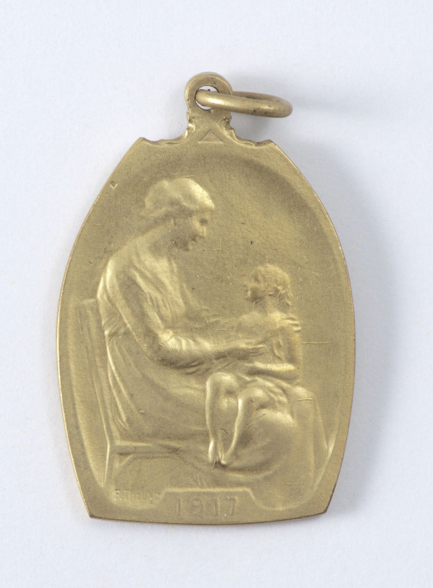 Goldmedaille mit einer Reliefdarstellung einer Frau in einem weißen Kleid mit einem Dutt, die ein Kind hält, und der Inschrift "Mutter und Kind" in Kursivschrift.