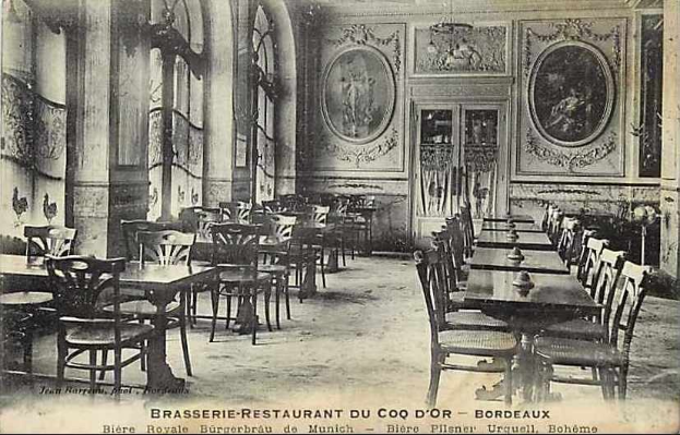 Schwarz-weiß-Foto eines alten Brasserie-Restaurant-Interieurs im Coq d'or, Bordeaux, Frankreich, mit Tischen, Stühlen, Wandgemälden und einer zentralen Tür.
