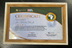 Ein gerahmtes Abschlusszertifikat wird auf einem Tisch präsentiert, mit Text, der wahrscheinlich den Abschluss eines Kurses anzeigt.